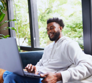 A man sitting in a chair using a laptop.